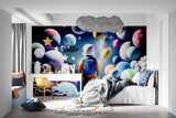 Space-themed wallpaper bringing color to nursery with rocking chair