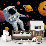 Space adventure wallpaper creates cosmic dreams in a modern kids bedroom, with happy planets and floating astronaut design