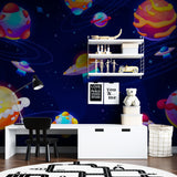 Nursery featuring space wallpaper mural with gentle galaxy colors and fun spacecraft