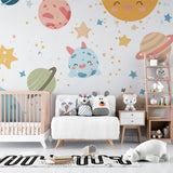Space theme wallpaper creating a magical atmosphere in a modern nursery with white furniture