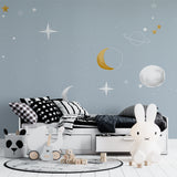 Celestial wall mural brightening a kid's reading nook with golden moon details