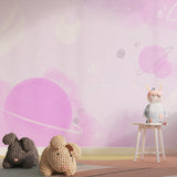 Pink galaxy wallpaper creating a dreamy atmosphere in a modern nursery with floating planets and stars