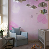 Space themed wall mural in a child's bedroom showing soft pink cosmic design