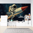 Space adventure wallpaper displayed in a modern kids bedroom, showing retro astronaut and rocket design against dark blue walls