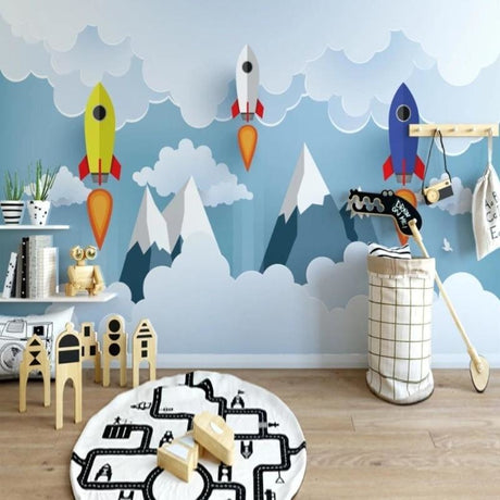 Space themed wallpaper with rockets and mountains shown in a bright modern kids bedroom with blue accents