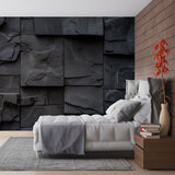 Modern living room with black slate stone effect wallpaper creating dramatic accent wall