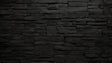 Black stone wall mural creating drama in modern living room with gray sofa and metal accents