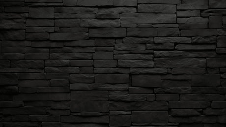 Black stone wall mural creating drama in modern living room with gray sofa and metal accents