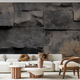 Black stone effect wallpaper creating dramatic accent wall in modern living room with leather furniture and metal accents