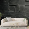 Modern black stone block wallpaper creating depth in a minimalist living room with ambient lighting