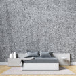 Modern grey stone wallpaper creating depth in a minimalist living room with natural light
