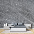 Modern grey stone effect wallpaper in contemporary living room with natural light highlighting metallic details