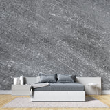 Modern grey stone effect wallpaper in contemporary living room with natural light highlighting metallic details