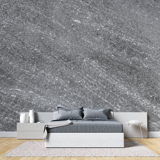 Modern grey stone effect wallpaper in contemporary living room with natural light highlighting metallic details