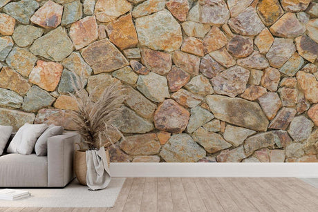 Stone wall mural creating a stunning accent wall in a modern living room with earth-toned furniture and natural light