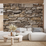 Stone effect wallpaper creating a stunning accent wall in modern living room with grey sofa and natural decor