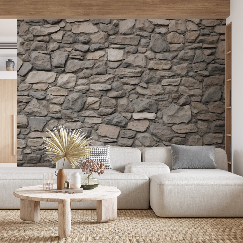 Stone wall mural creating a stunning accent wall in a modern living room with grey furniture and natural lighting