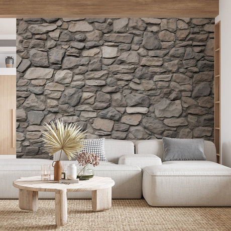 Stone wall mural creating a stunning accent wall in a modern living room with grey furniture and natural lighting