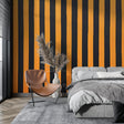 Modern striped wallpaper in orange and black making a bold statement in a minimalist living room