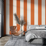 Modern living room with orange and white striped wallpaper creating a bright, energetic atmosphere