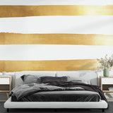 Gold striped wallpaper creating an elegant atmosphere in a modern living room with tall windows and cream furniture