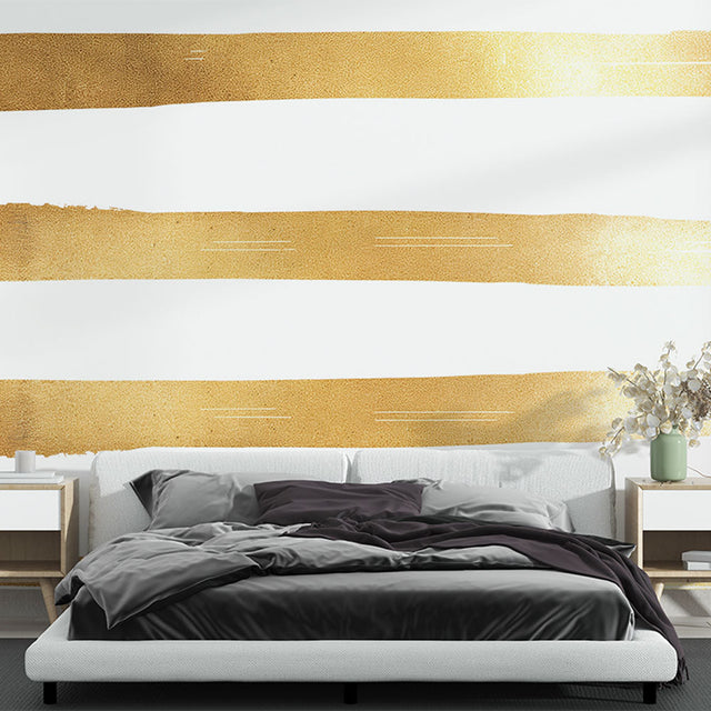 Gold striped wallpaper creating an elegant atmosphere in a modern living room with tall windows and cream furniture