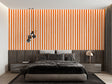Modern orange striped wallpaper in a bright living room creating visual height and energy