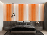 Modern orange striped wallpaper in a bright living room creating visual height and energy
