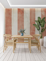 Modern dining room featuring vertical striped wallpaper in warm terracotta and cream tones