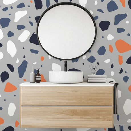Modern Terrazzo wallpaper with orange and navy shapes brightening a minimalist living room with natural light