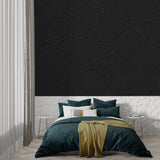 Black stone textured wallpaper in modern living room with grey sofa and natural light