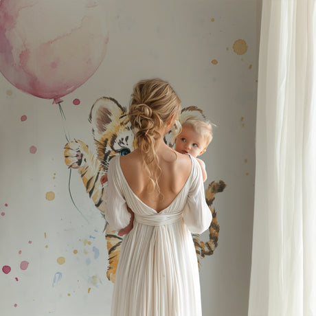 Tiger cub balloon wallpaper in a bright nursery with white furniture and soft pink accents