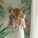 Jungle tiger mural in baby room with wooden accents and pastel decor