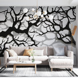 Black tree branch wallpaper creating dramatic impact in a modern living room with natural light and minimal furniture