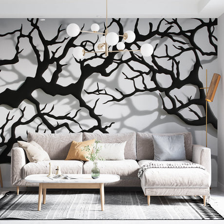 Black tree branch wallpaper creating dramatic impact in a modern living room with natural light and minimal furniture