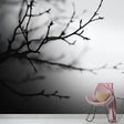 Minimalist black and white branch wallpaper creating depth in a modern living room with clean furniture