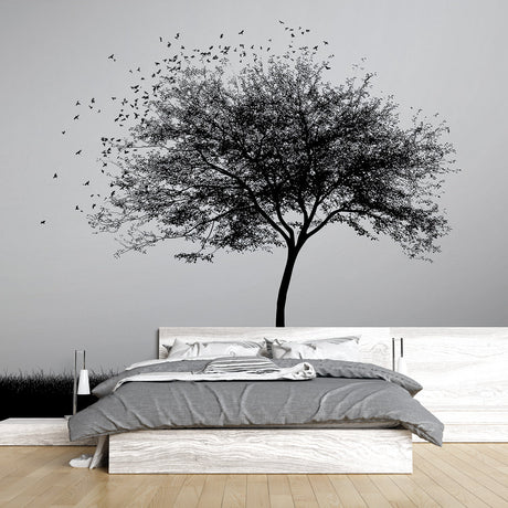 Black and white tree mural wallpaper creating a striking focal point in a modern minimalist living room