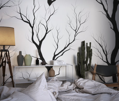 Black tree silhouette wallpaper in modern living room with grey sofa and natural light