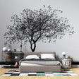 Black and white tree wallpaper creating a stunning focal point in a minimalist living room with modern furniture