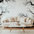 Black tree branch wallpaper creating depth in modern living room with grey sofa and natural light