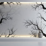Minimalist bedroom featuring black tree silhouette wallpaper with white bedding
