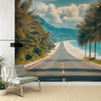 Tropical beach wallpaper with coastal road and palm trees creating depth in a bright modern living room