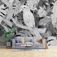 Modern living room featuring a striking Tropical Birds wallpaper with black and white parrot and monstera leaves