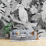 Modern living room featuring a striking Tropical Birds wallpaper with black and white parrot and monstera leaves