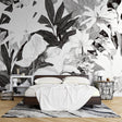 Black and white tropical leaf mural wallpaper creating dramatic contrast in modern living room setting