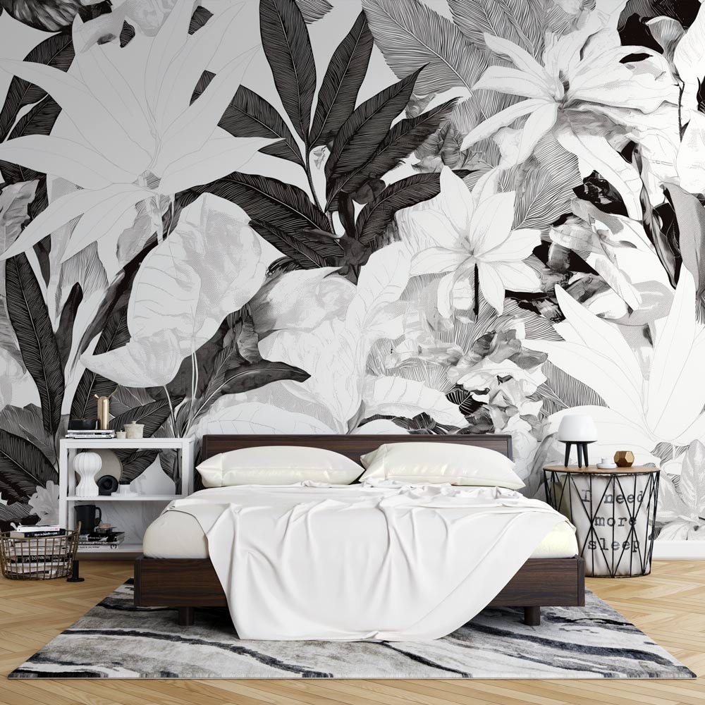 Black and white tropical leaf mural wallpaper creating dramatic contrast in modern living room setting