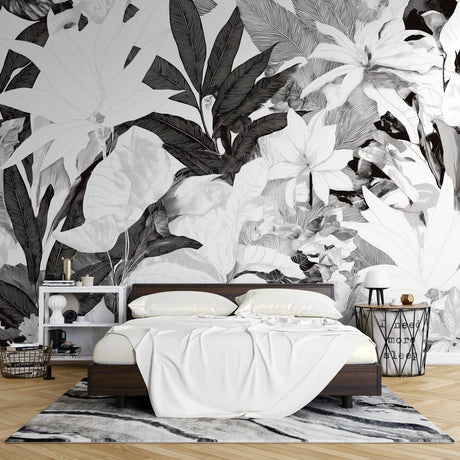 Black and white tropical leaf mural wallpaper creating dramatic contrast in modern living room setting