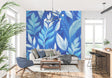 Blue tropical palm leaf wallpaper in modern living room with white sofa and natural light