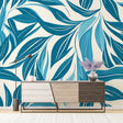 Modern blue leaf wallpaper displayed in a bright living room, creating a fresh tropical atmosphere with natural light