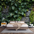 Tropical leaf wallpaper in modern living room showing lush green foliage against textured stone wall